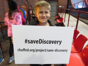 Happy boy holding save Discovery sign